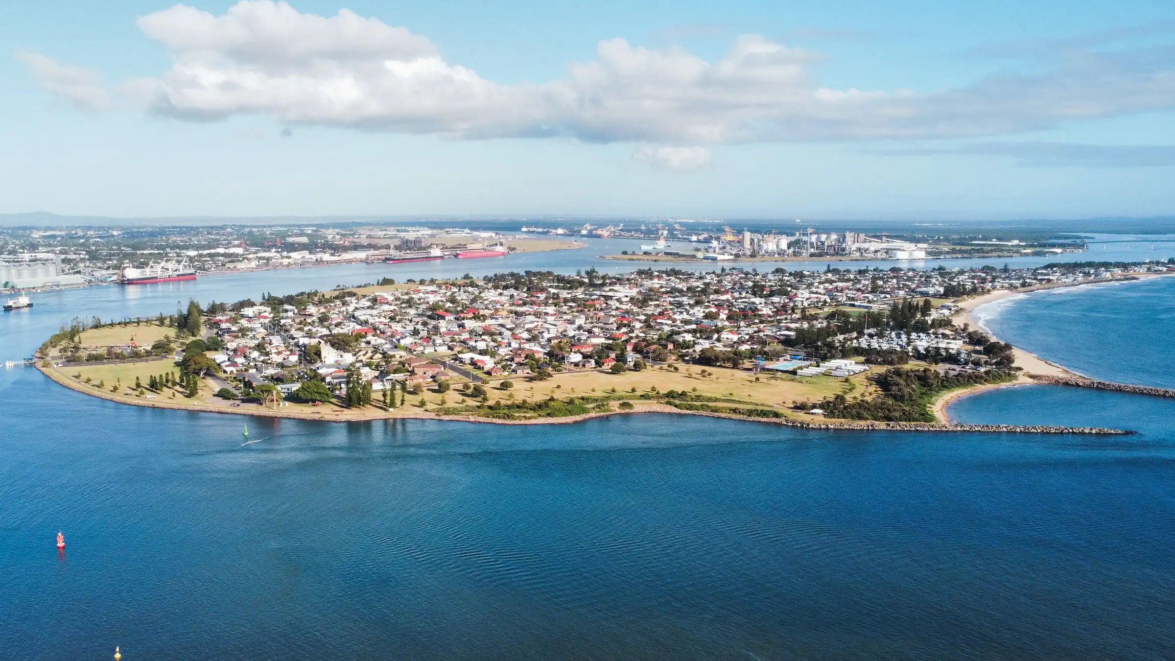 Aerial view over Stockton and the mouth of Newcastle Harbour, with the port behind